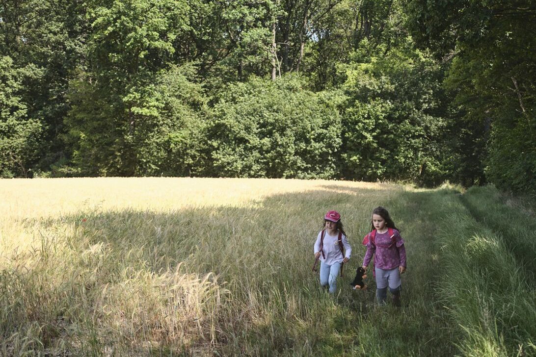 Zwei Mädchen auf einer grünen Wiese.