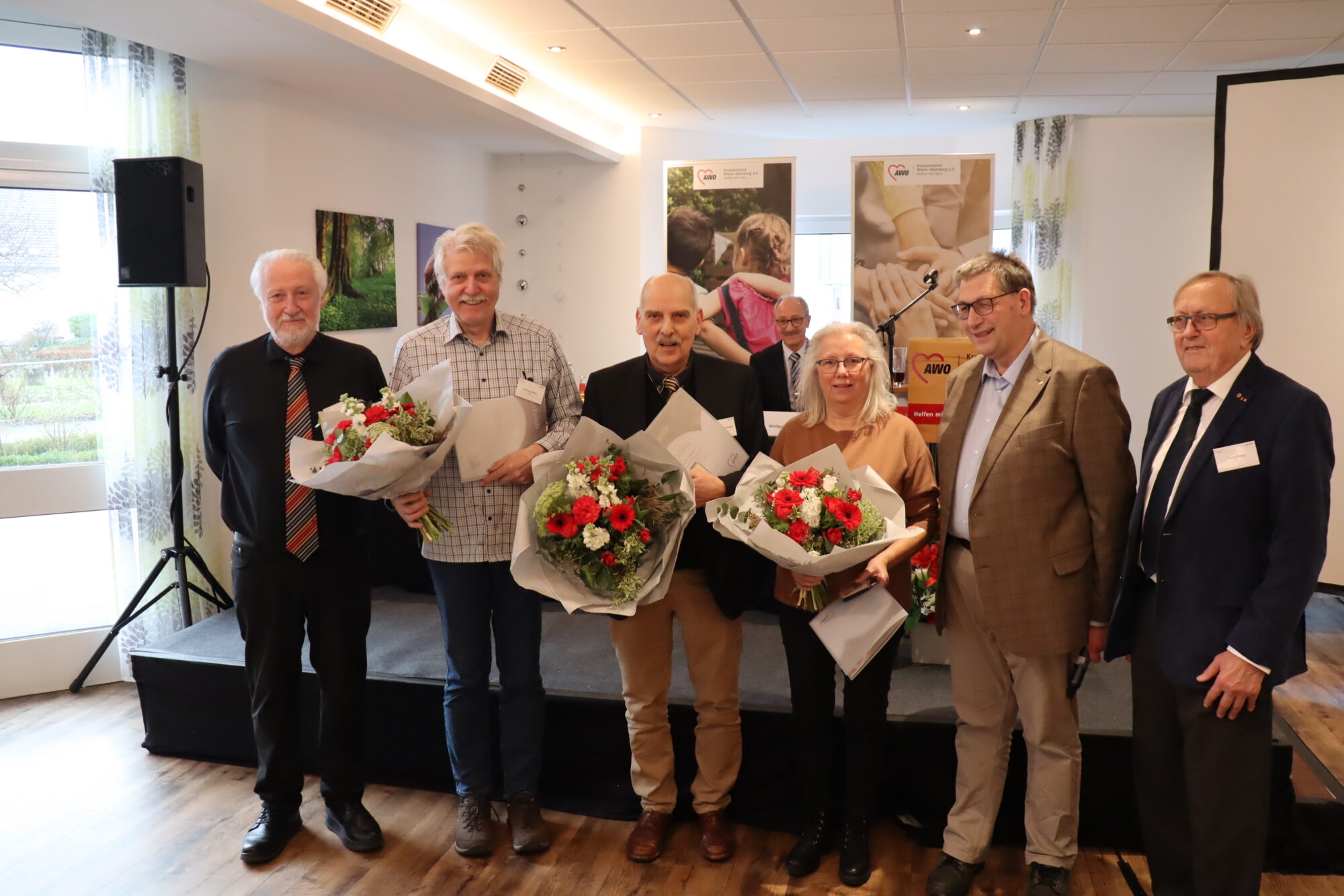 Ehrungen Präsidiumsvorsitzender Ralph Kür steht neben vier Männern und einer Frau bei einer Ehrung. Drei von ihnen halten Blumensträuße.