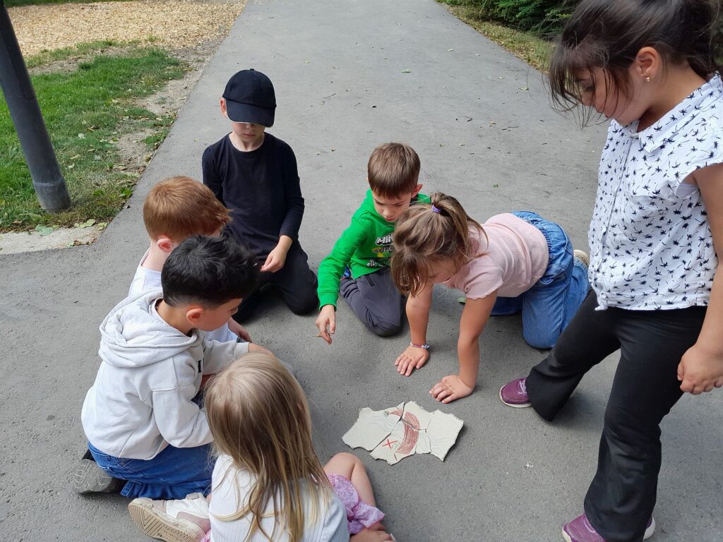 Die Kinder auf Schatzsuche mit einem gezeichneten Schatzplan