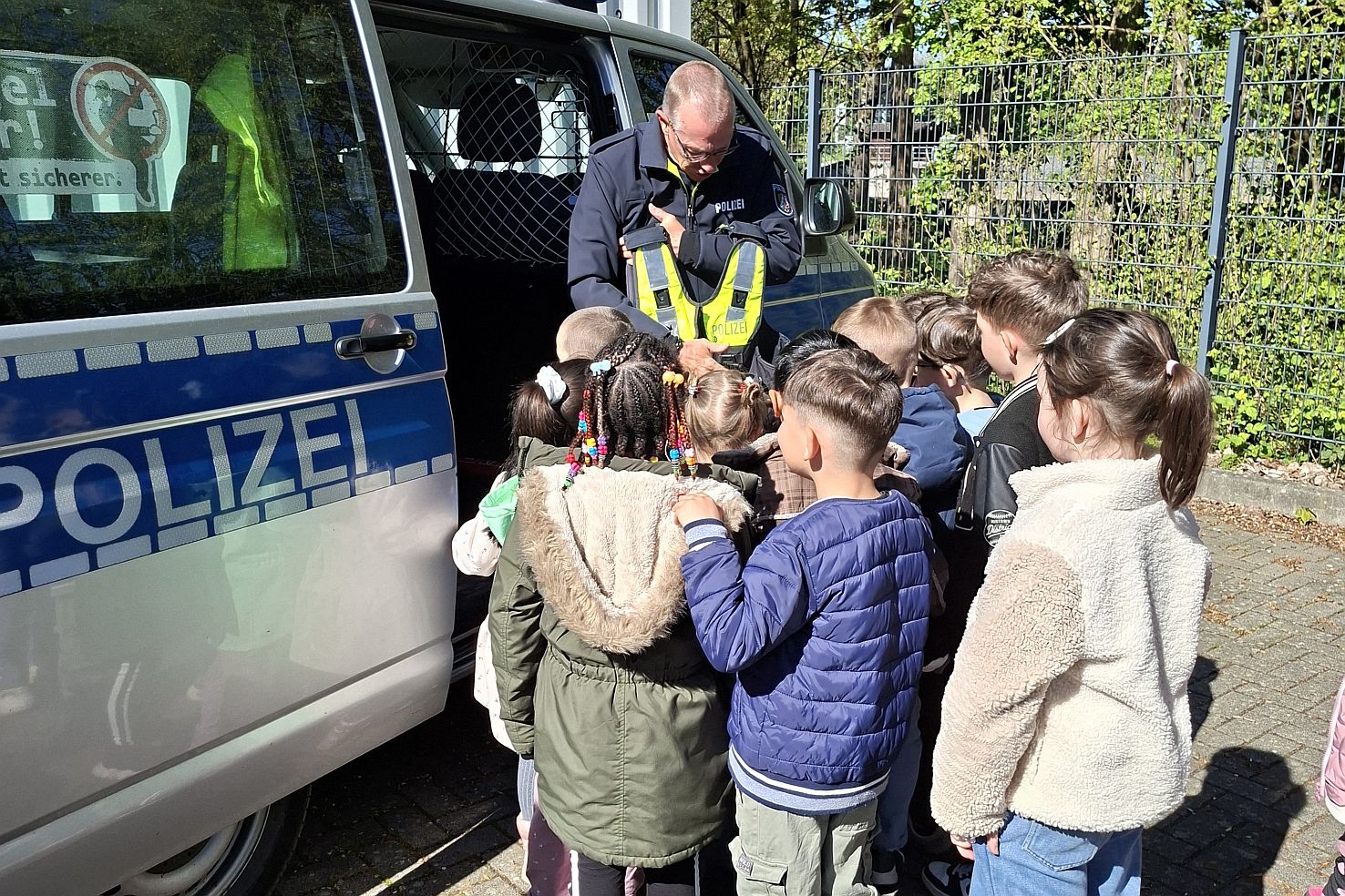 Besuch Polizeiwache VSK 2026 Kinder stehen vor einem Polizeibus