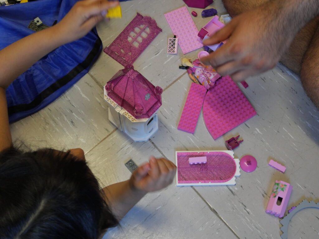 Kinderhände mit pinken Legosteinen