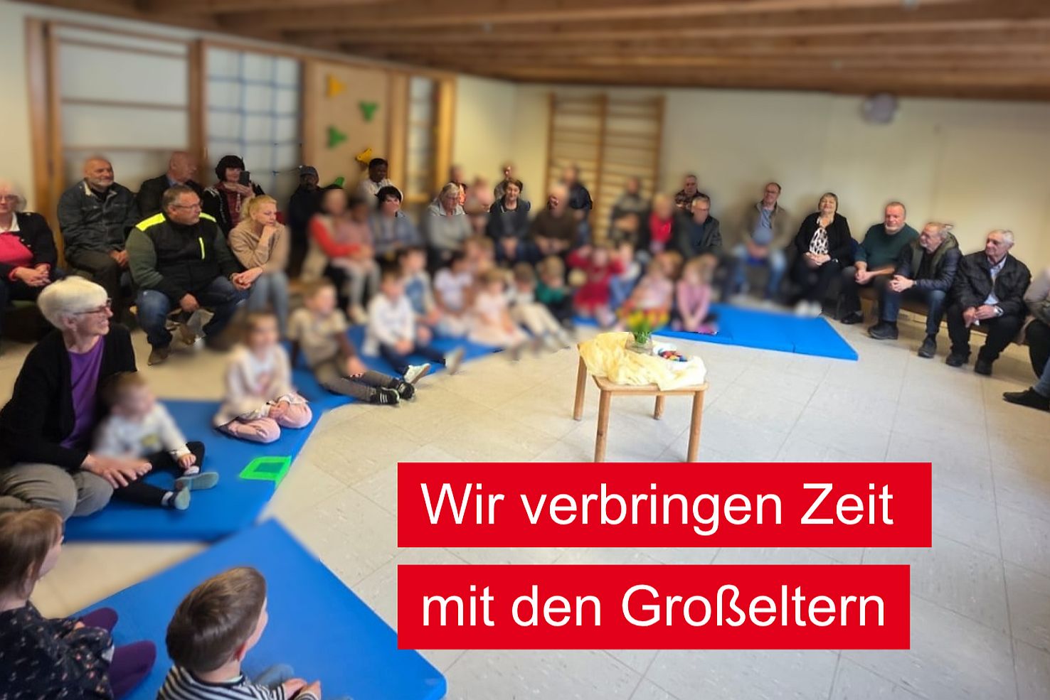 Kinder und Großeltern sitzen in der Turnhalle