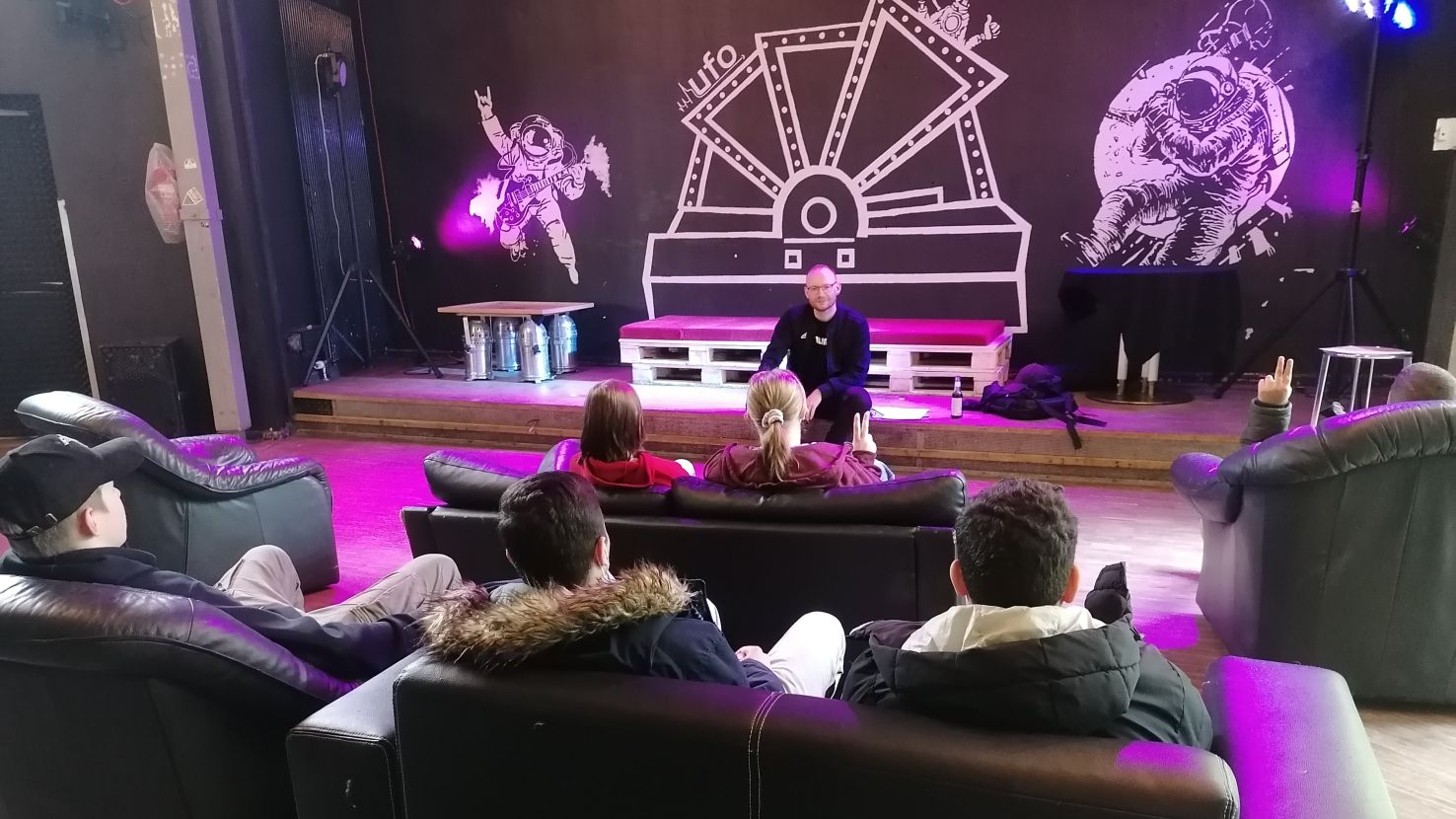 Beratung_Ufo Jugendzentrum Mehrere junge Menschen sitzen auf Sofas und hören einem Vortrag zu