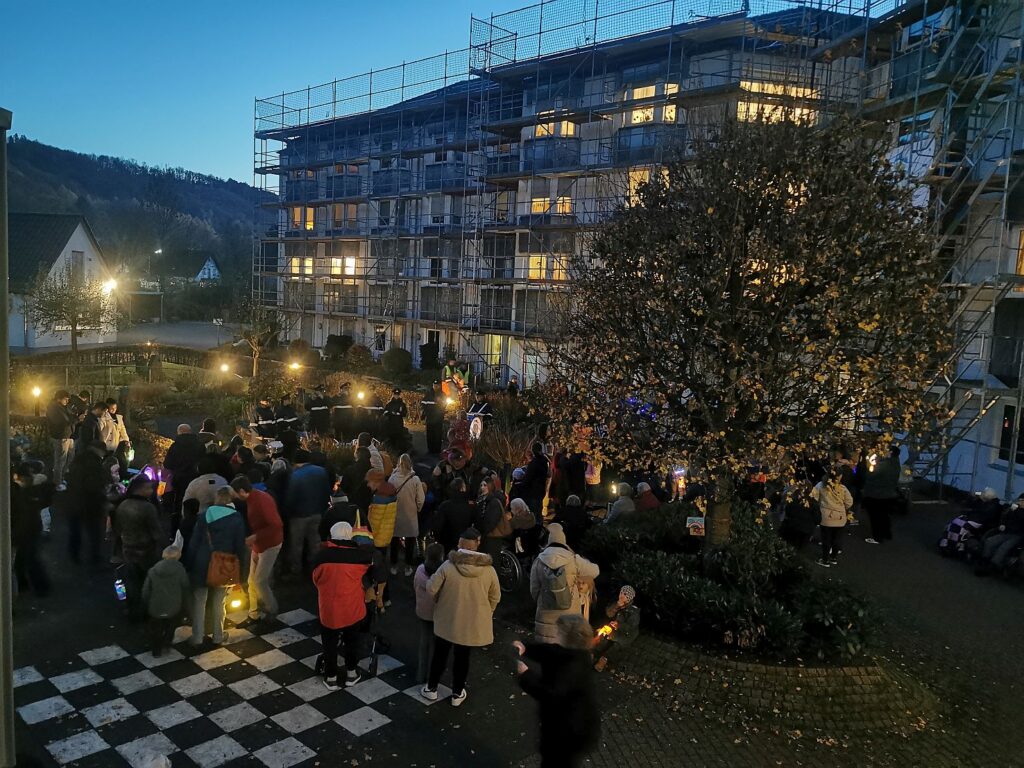 Auf dem Innenhof des Altenzentrums stehen Menschen mit Laternen um eine Musikkapelle