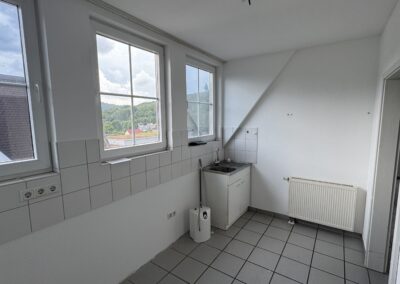 Küche mit drei großen Fenstern und weißen Fliesen