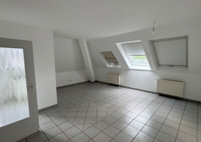 großes Zimmer mit Dachschräge und drei Dachfenstern