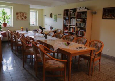 Gemeinschaftsraum mit großem Tisch und Bücherregal