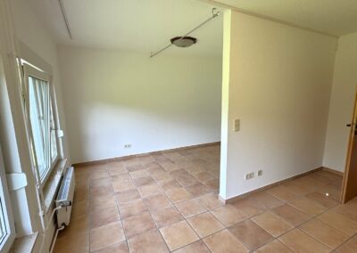 Ein Zimmer mit zwei großen Fenstern, weiße Wände