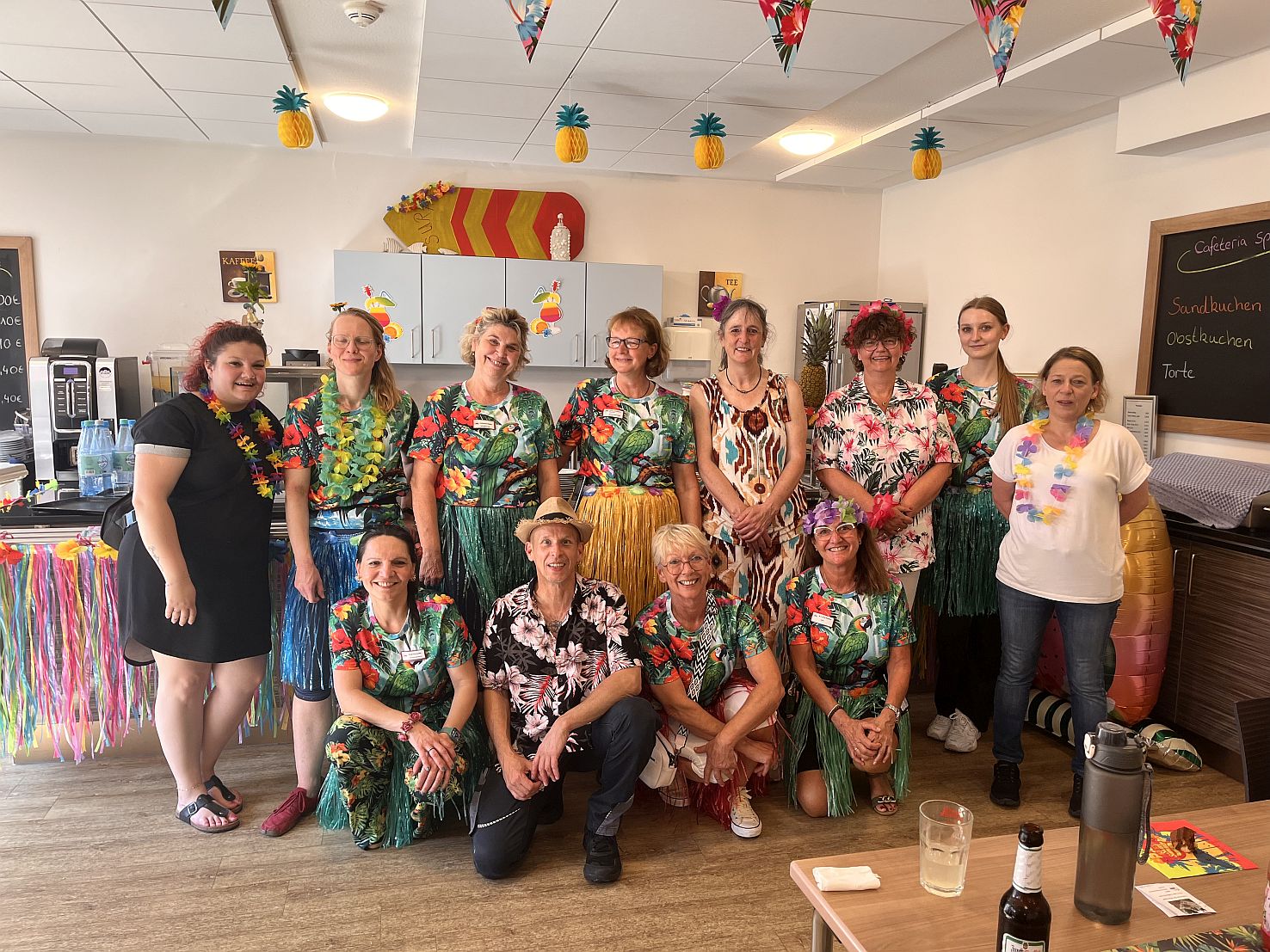 Gruppenbild des Teams mit umgehängten Blütenkränzen
