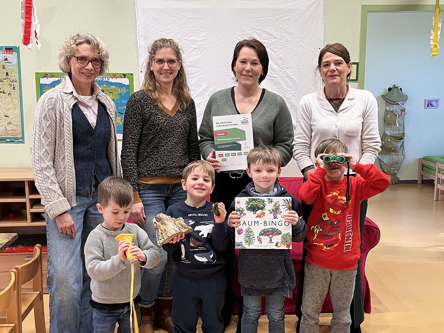Kinder und Mitarbeitende der Kita zeigen die Urkunde zur Zertifizierung
